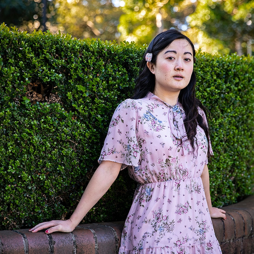 The writer Jessie Tu standing in front of a hedge