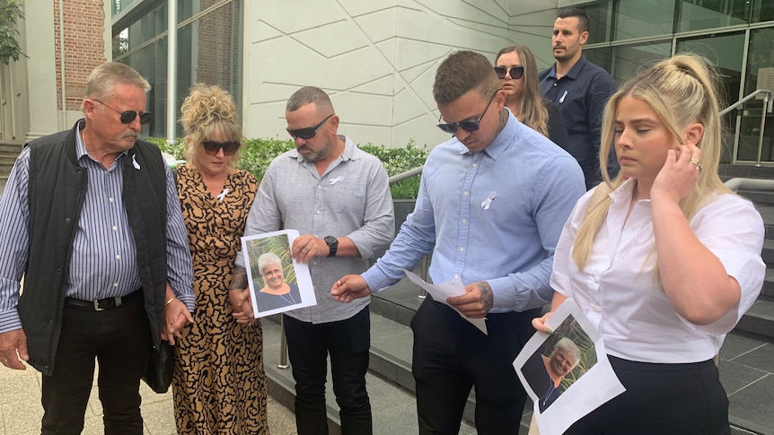Five people standing outside court holding up photos of Roselyn