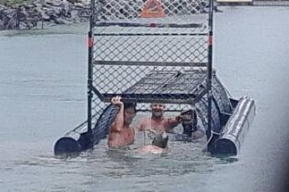 Four men climb into a baited crocodile trap at the Port Douglas marina in far north Queensland.