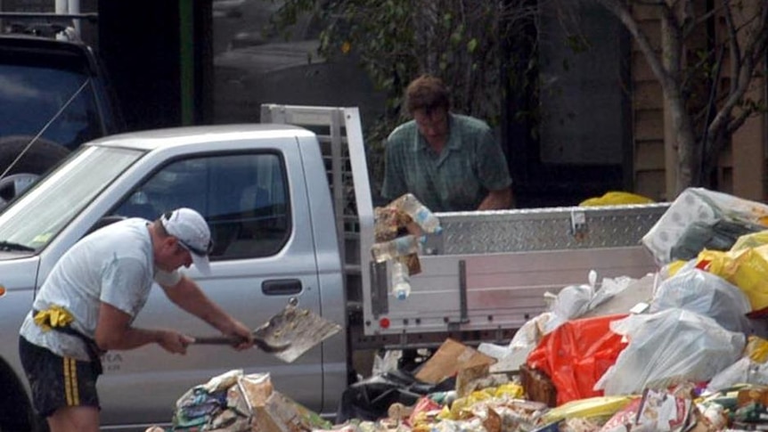Shop owners at the inner Brisbane suburb of Rosalie clean up after floodwaters subsided on January 14, 2011.