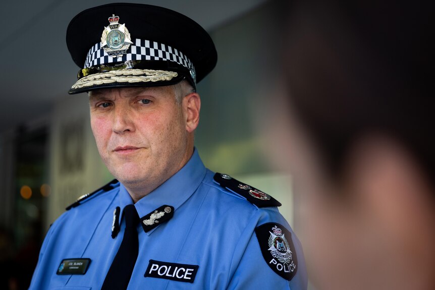 A head and shoulders shot of WA Police Commissioner Col Blanch with someone else's head out of focus on the right.