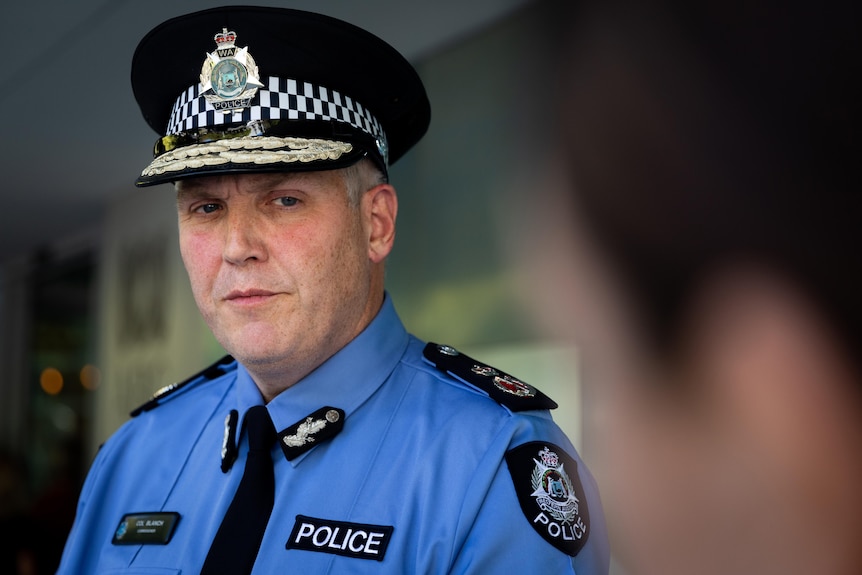 A head and shoulders shot of WA Police Commissioner Col Blanch with someone else's head out of focus on the right.