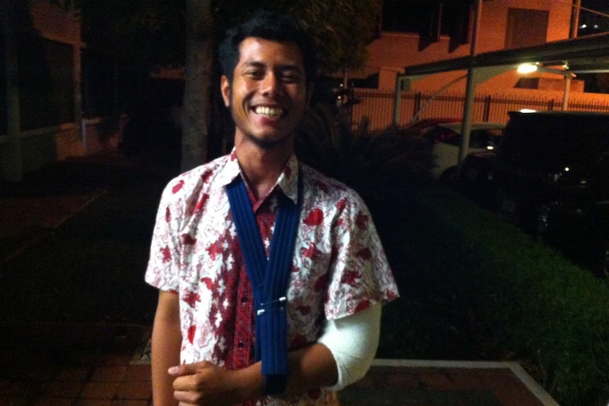 Indonesia student Dimas Arif Rohman Hakim smiles despite having his broken left arm in a sling