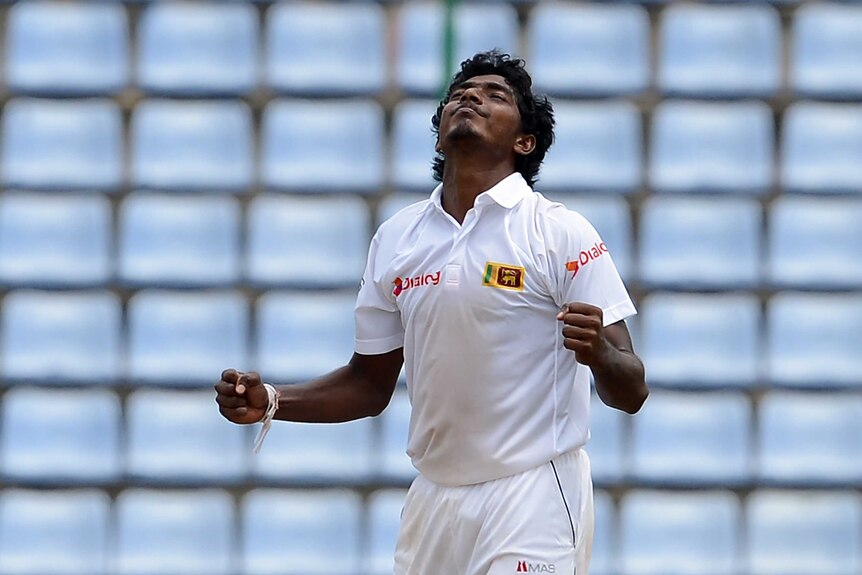 Sri Lanka's Lakshan Sandakan clenches his fists to celebrate taking a wicket.