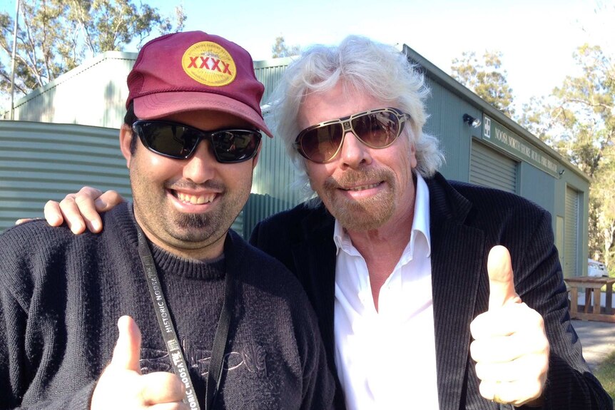 A man with older man who is Sir Richard Branson, both are smiling