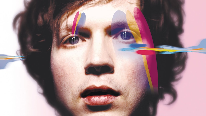 A close up shot of Beck with computer-added pink, blue and yellow splotches over the sides of his face