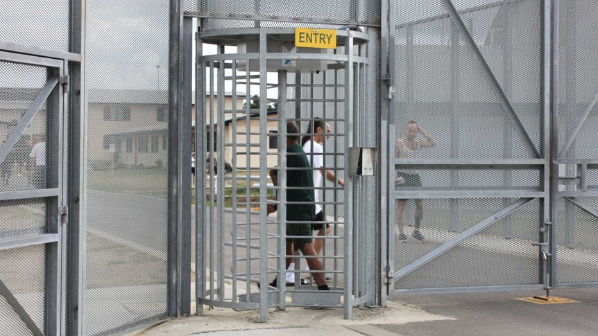 Prisoners move around behind security fencing at Fulham Correctional Centre