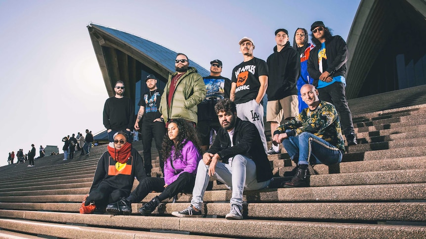 Colour photo of the Briggs' Bad Apples House Party line-up posing on the steps of the Sydney Opera House.