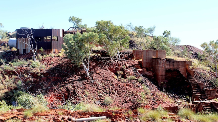 A picture of decrepit mining infrastructure overgrown by bushland