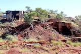 A picture of decrepit mining infrastructure overgrown by bushland