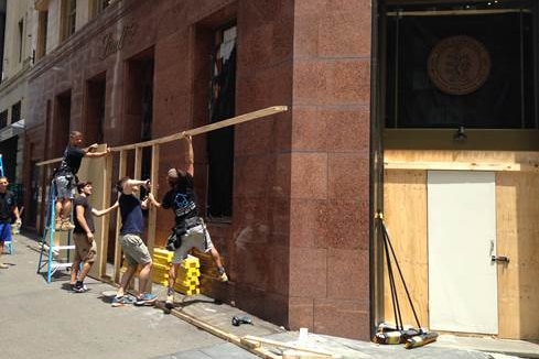 Workers repair the exterior of the Lindt cafe