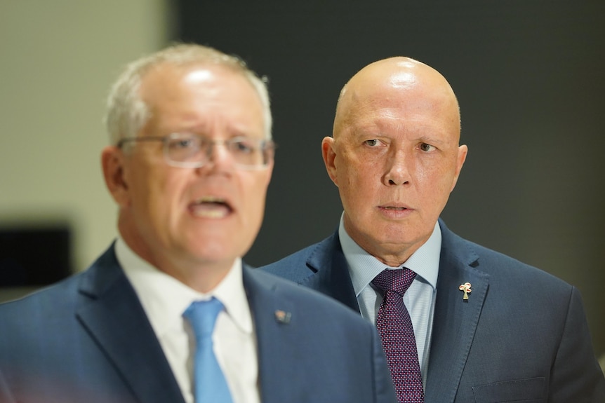 Peter Dutton looks on as Scott Morrison speaks.