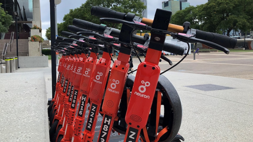 A row of orange Neuron electric scooters at Brisbane's South Bank
