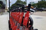 A row of orange Neuron electric scooters at Brisbane's South Bank
