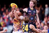 Max Michalanney leaps highest to try to punch the ball out of Joe Daniher's hands