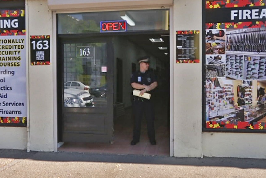 Police officer at door of Marksman firing range Adelaide
