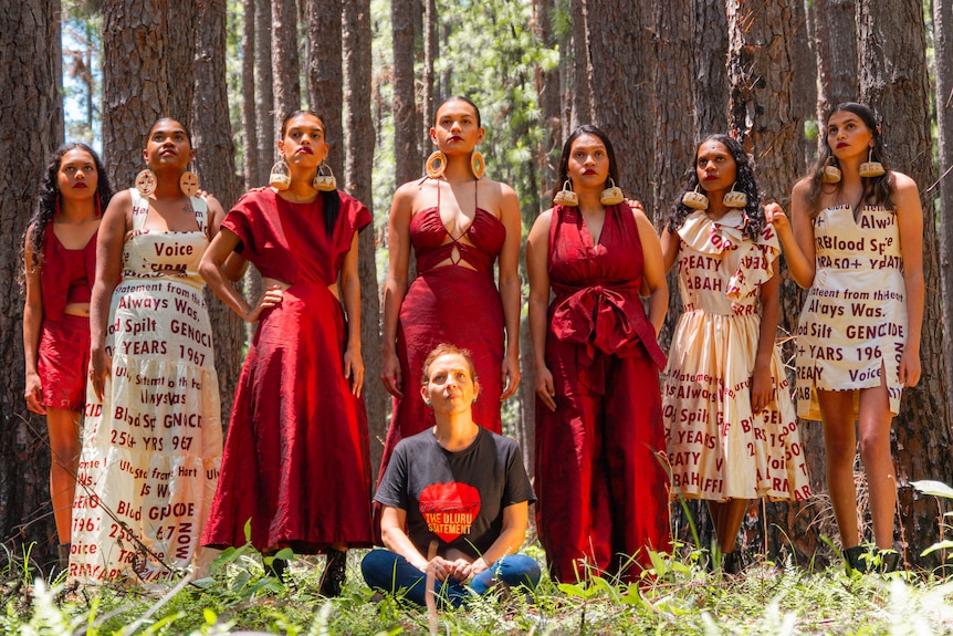 Eight women in a forest on a fashion photoshoot.