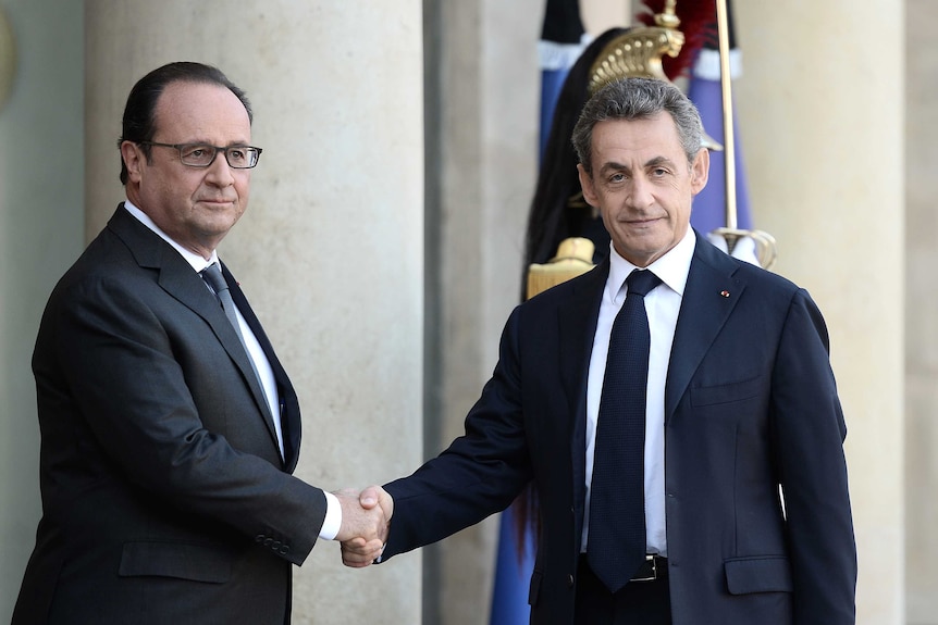 French president Francois Hollande (left) greets opposition leader Nicolas Sarkozy