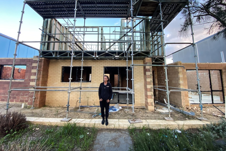 Cindy Richardson stands in front of her incomplete home in the Nicheliving Tapping development