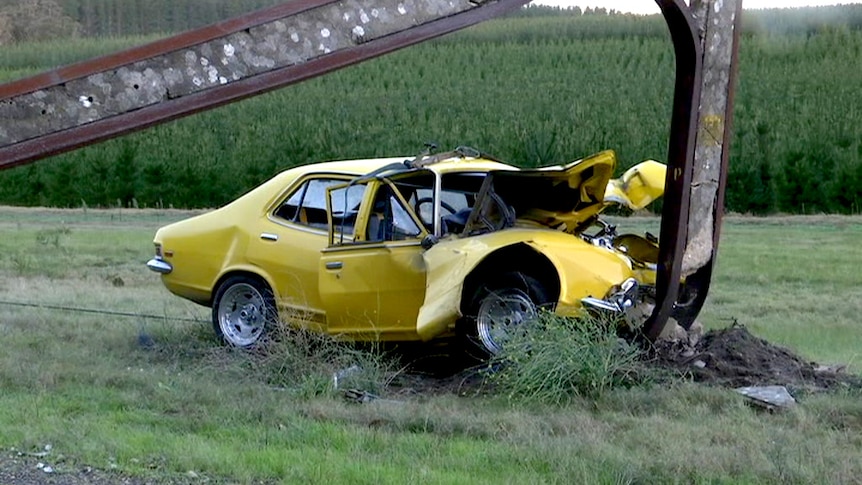 A car crumpled against a power pole.