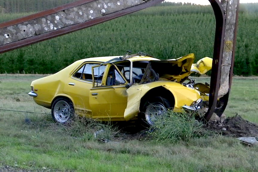 A car crumpled against a power pole.