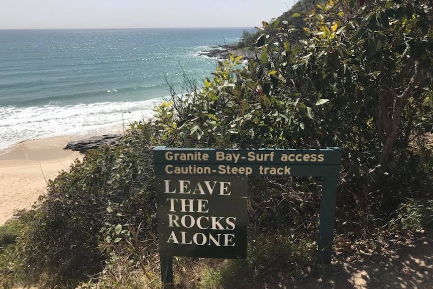 A sign post at the entrance to a beach