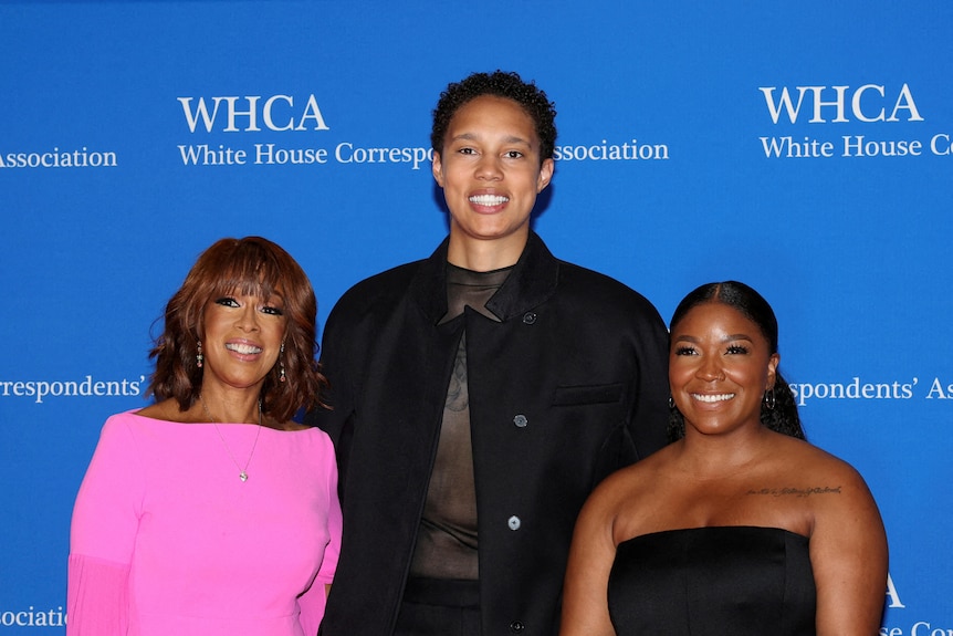 Brittney Griner stands with gayle king and cherelle griner stand on a red carpet