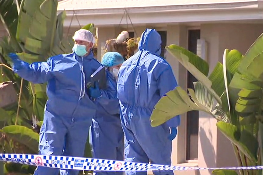 Police officers in blue overalls and masks outside a house