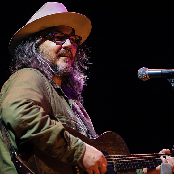 Jeff Tweedy from Wilco playing guitar at a live show
