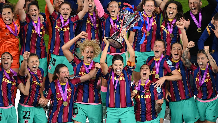 Barcelona players celebrate wildly as Vicky Losada holds up the Champions League trophy