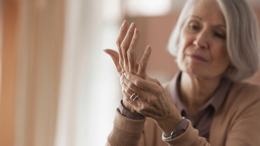 Older woman rubbing her hands.