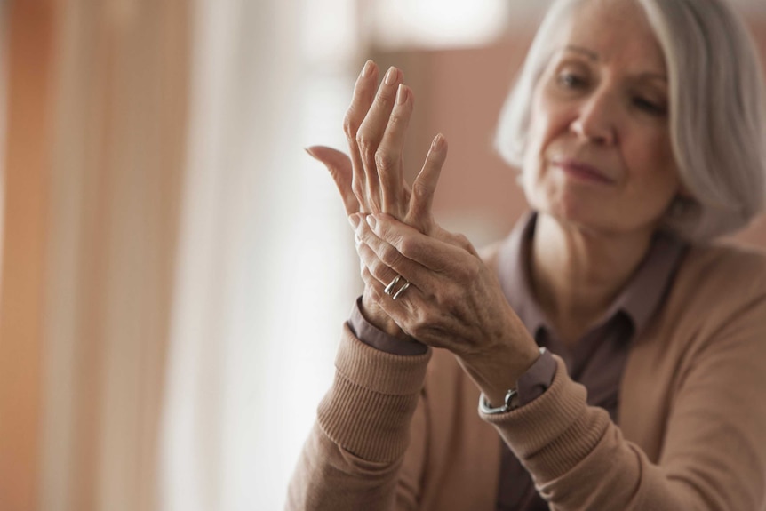 Older woman rubbing her hands.