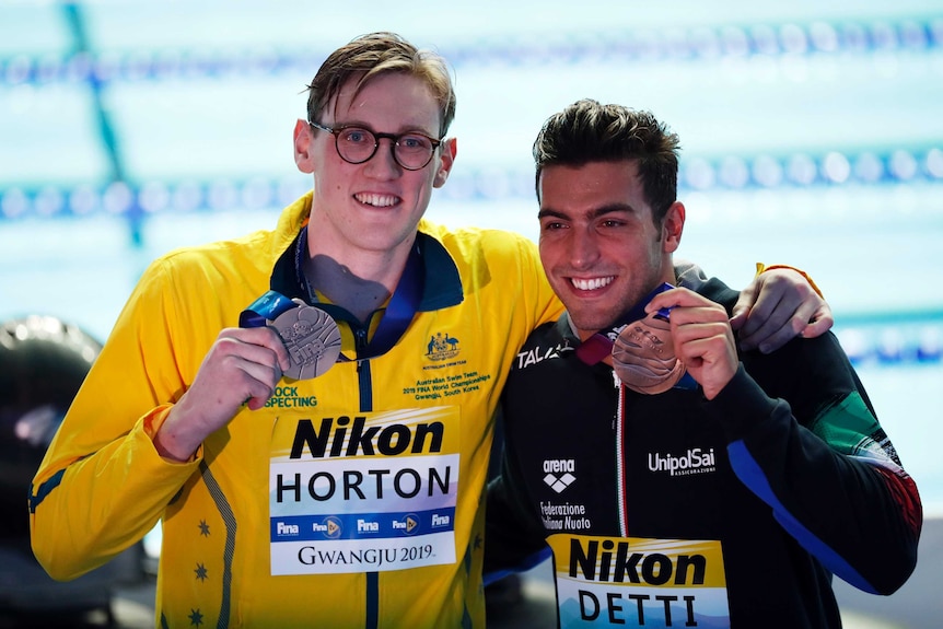 Australian swimmer Mack Horton shows off his silver medal and Italian swimmer Gabriele Detti shows off his bronze.