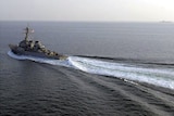 The USS Curtis Wilbur sailing on a clear ocean.