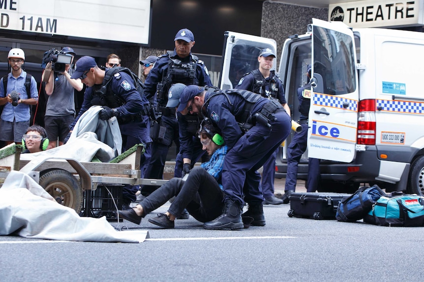 An Extinction Rebellion protester is placed under arrest by Queensland Police