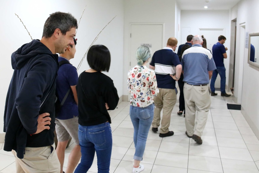 People line up to enter an elevator.