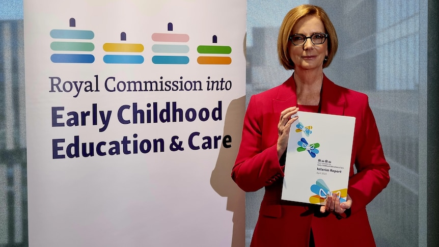 Julia Gillard holding a copy of the interim report