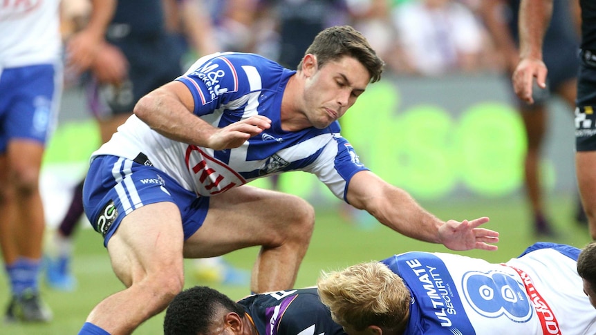 Tui Kamikamica puts the ball down for a try as he is tackled by the Bulldogs defence.