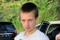 A 15-year-old boy with short hair wearing a white t-shirt.