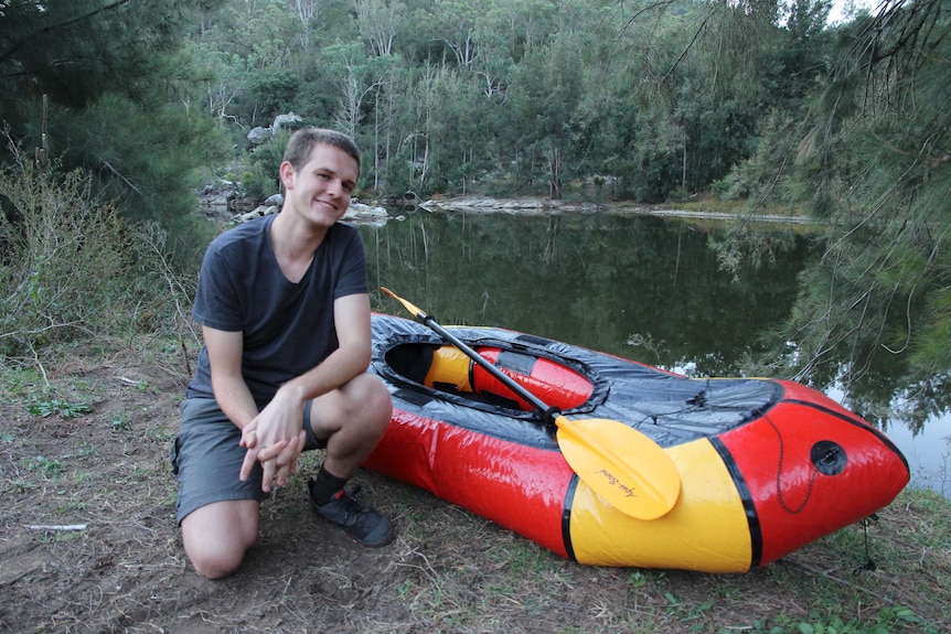 21-year-old environmental activist Harry Burkitt with a pack raft next to the Wollondilly river