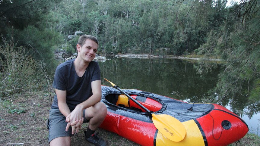 21 year old environmental activist Harry Burkitt with a pack raft next to the Wollondilly river