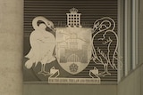 The ACT coat of arms features a castle, swords, crowns, two swans and the motto 'for the King, the law and the people'.