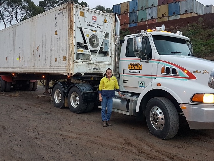 Truck driver Sarah Brosnan stands beside her semi trailer