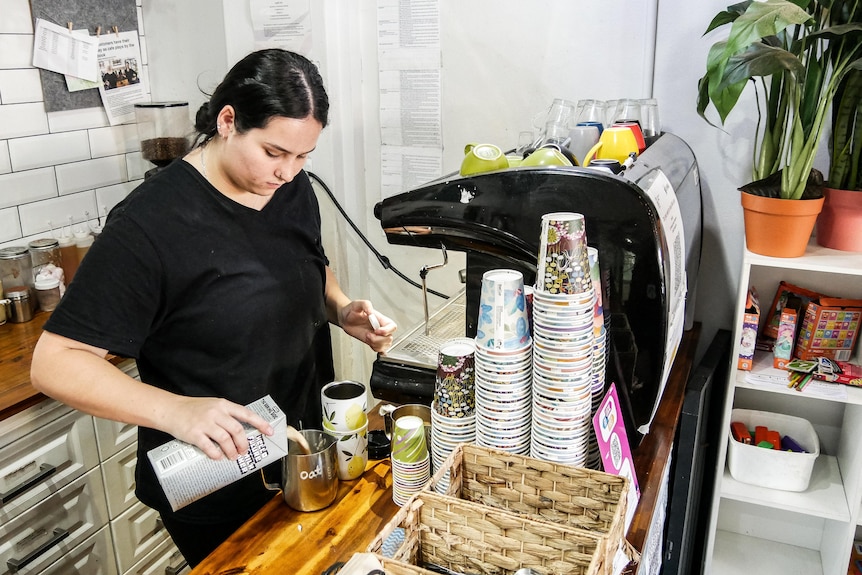 A woman making coffee in a cafe.  