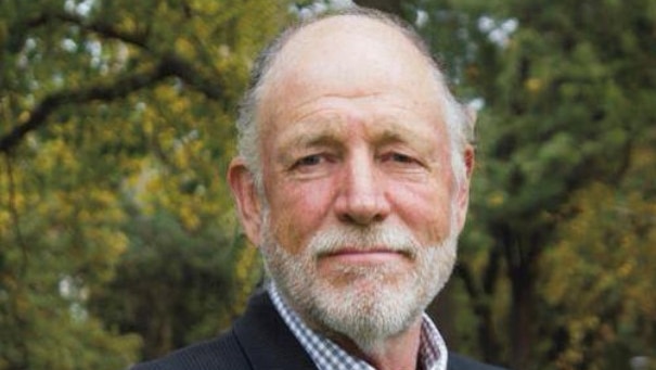 A close-up photo of a man wearing a suit and tie