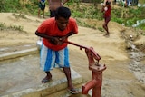 Abul Kalam using a hand pump to get access to water.