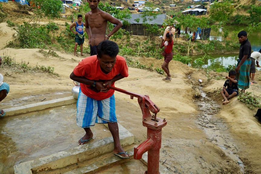 Abul Kalam using a hand pump to get access to water.