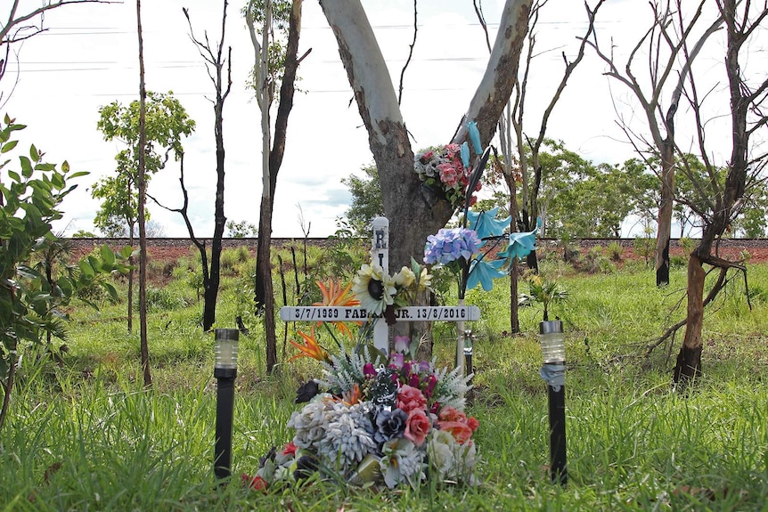 A roadside memorial embellished with flowers on the side of the Stuart Highway.