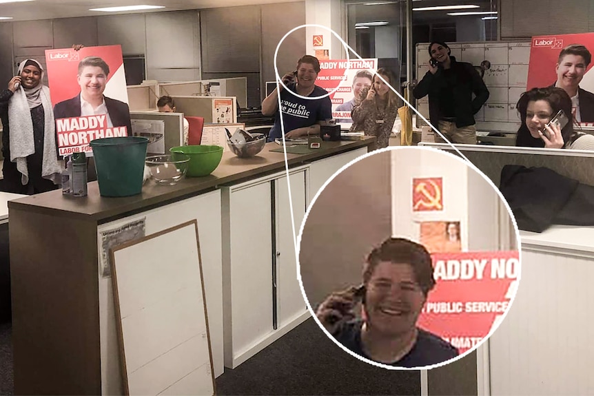 A woman in an office, with a small hammer and sickle poster on the wall.