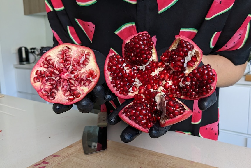 A side by side comparison of a halved pomegranate, and one cut properly.